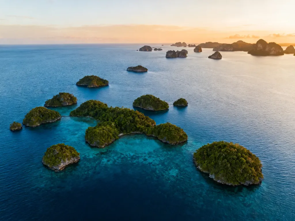 Widok z lotu ptaka na skandynawski archipelag z licznymi zielonymi wyspami otoczonymi błękitną wodą.